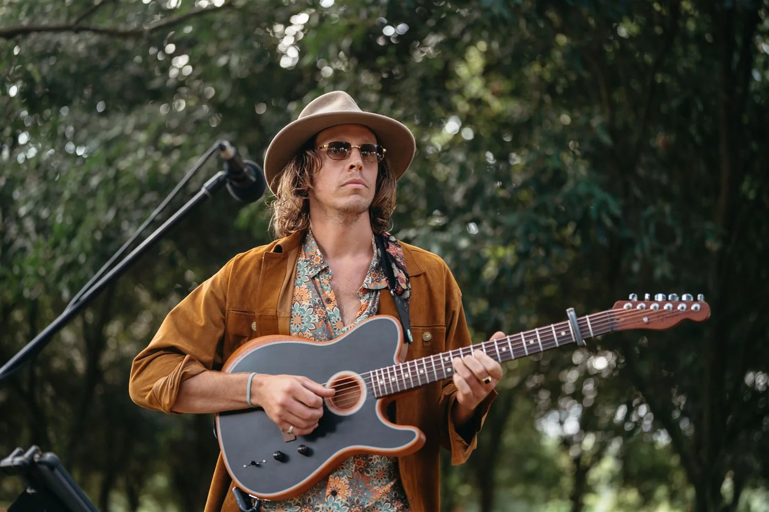Mitch Tolnay playing acoustic guitar outdoors