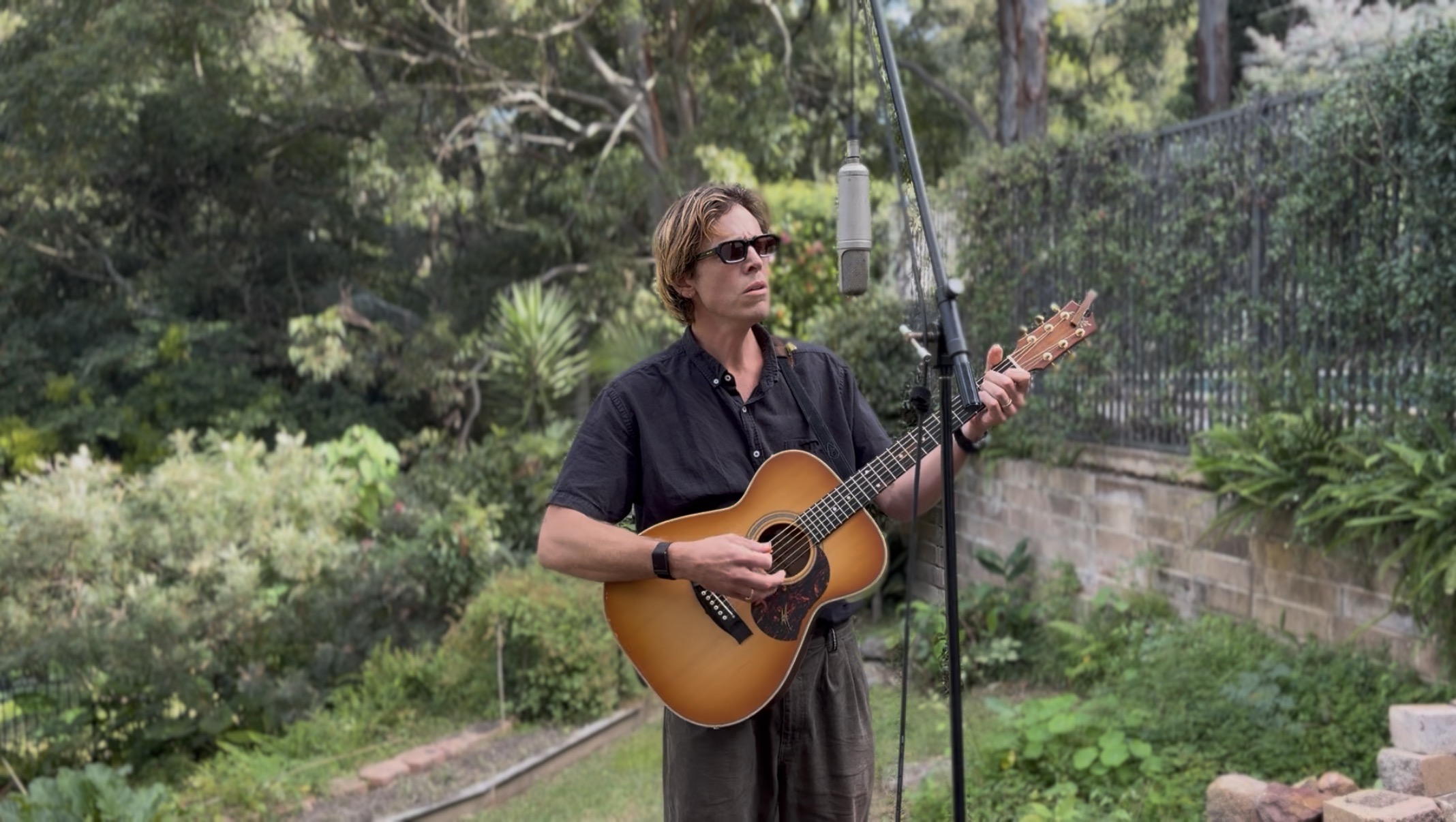 Mitch Tolnay playing guitar outdoors — click to watch